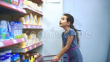 在杂货店买数字平板电脑的小女孩在网上购买奶酪产品。 超市里的小女孩